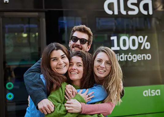 A Group Of People Hugging In Front Of Alsa Bus
